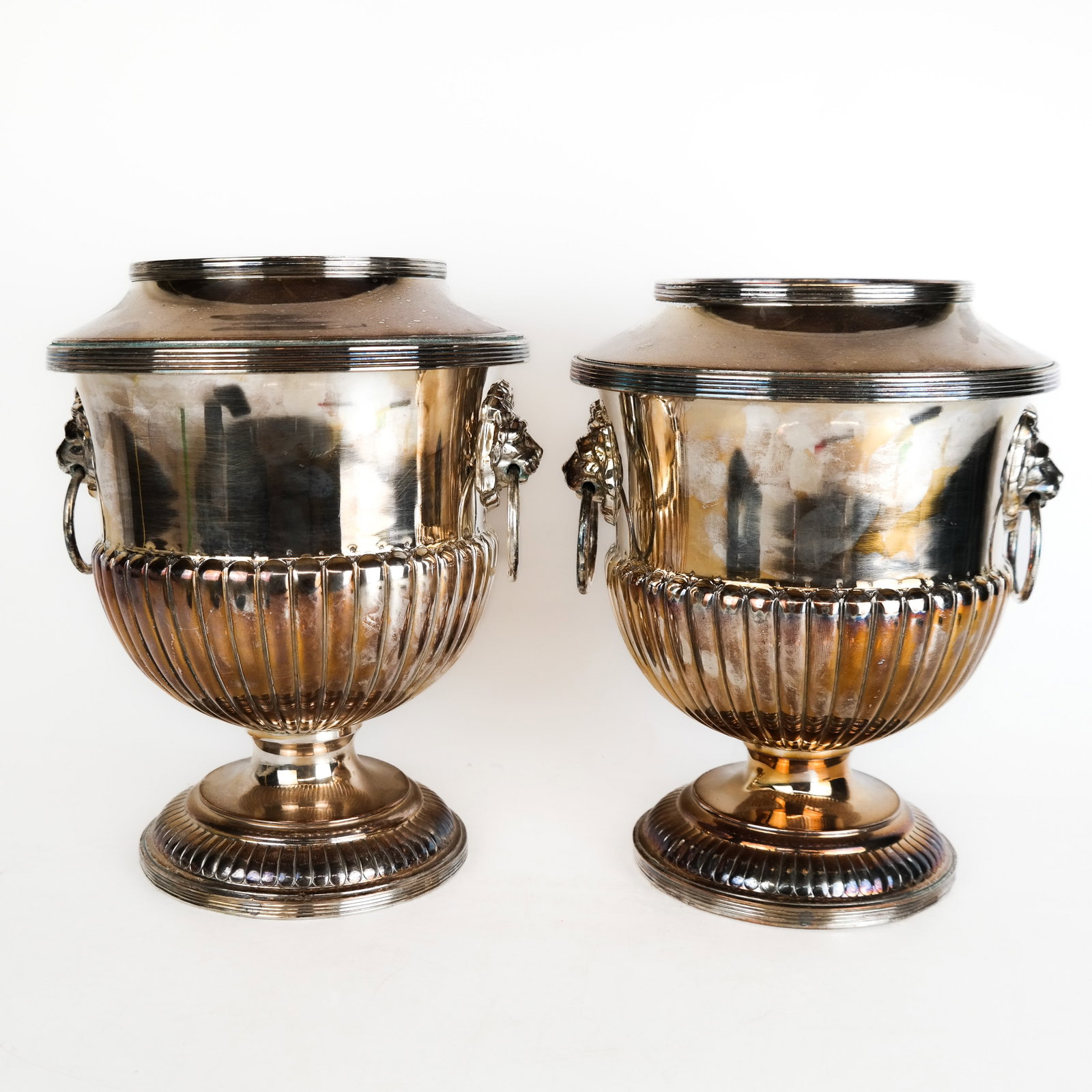 Pair of Silver Plate Wine Coolers: Pair of silver plate wine coolers with gadroon decoration and lion head handles, bearing heraldic motto and crest for the county of Kent, England. [10" H x 8" Diam.]. Dents to rims, overall with typic