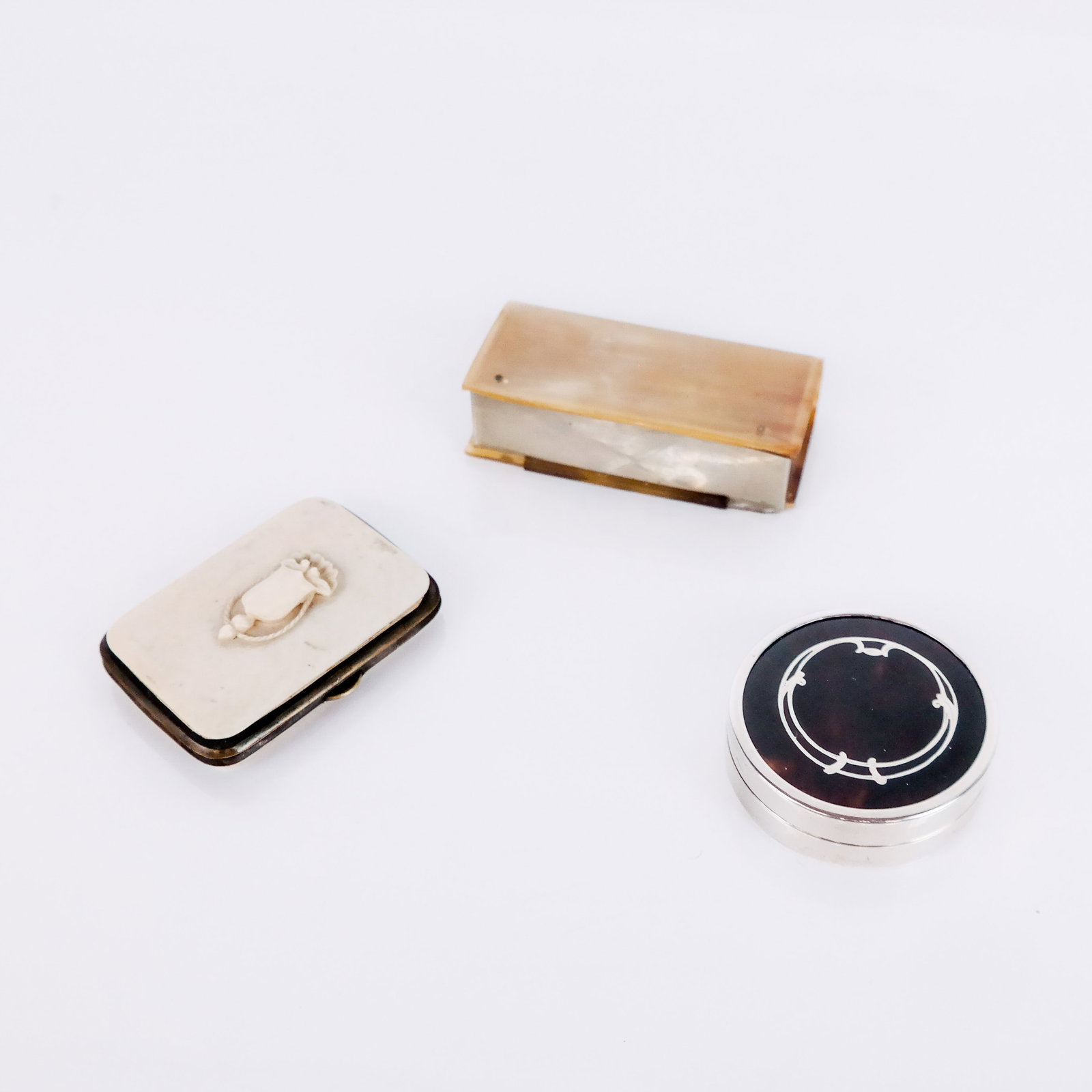Three Objects de Vertu: Three (3) objects de vertu, comprising an English silver compact, Birmingham, 1926, with illegible maker's mark; a carved bone coin purse, and a horn snuff box. [Snuff box: 7/8" H x 3 5/8" W x 1 5/8" 