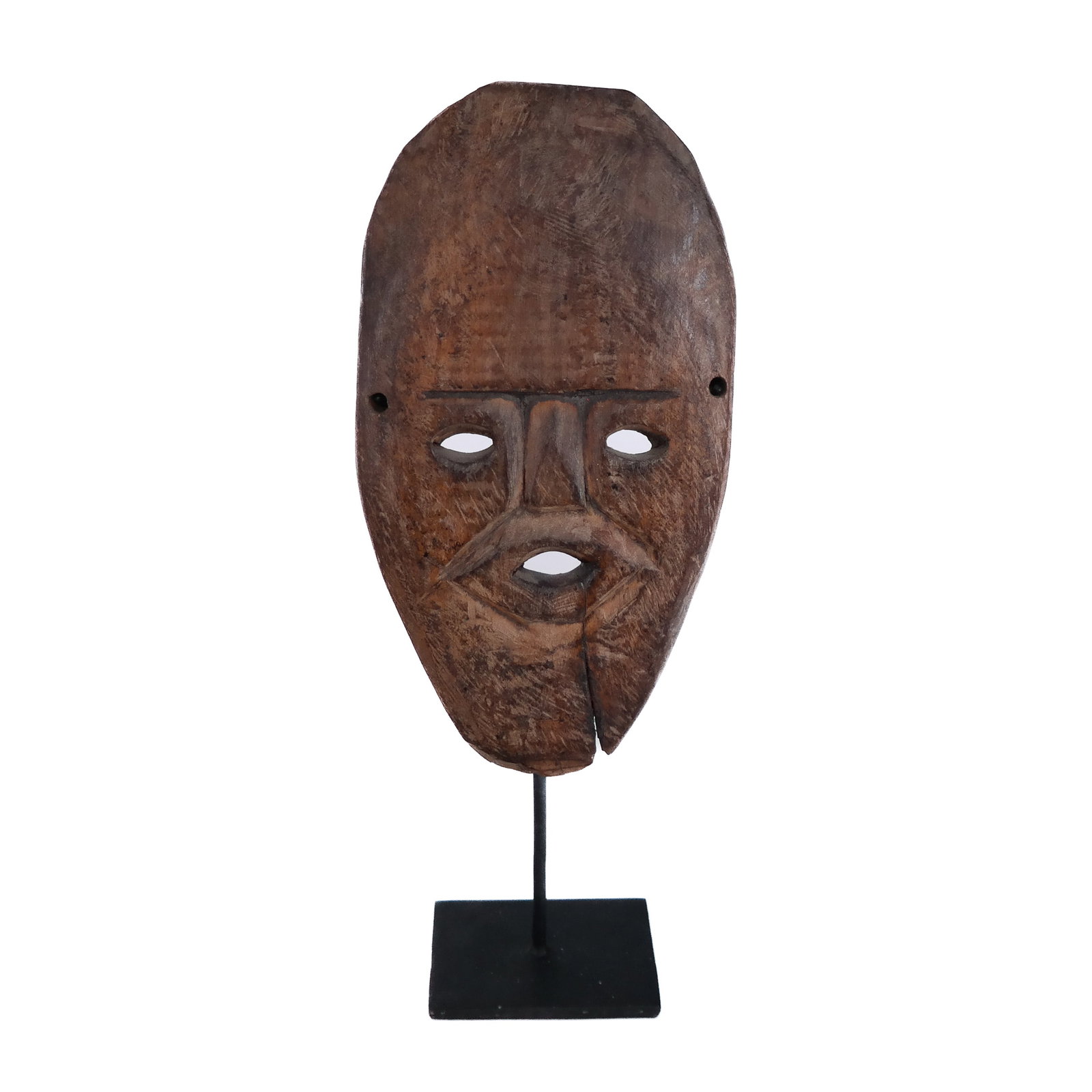 African Carved Mask on Stand: African carved wood mask on stand. Provenance: From the Collection of renowned architect and designer Thierry Despont. [Overall: 12" H x 4 1/2" W x 3" D]. Cracks, wear and marks.