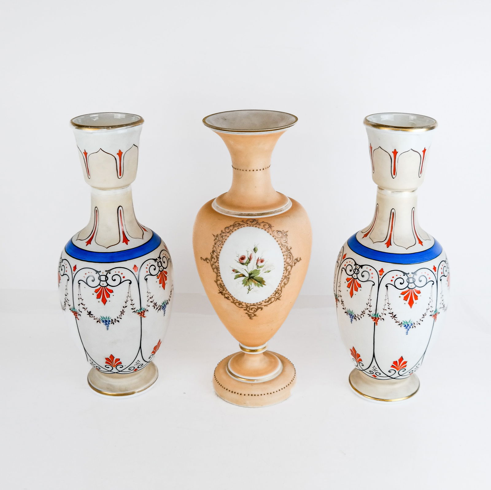 English Victorian Painted Milk Glass Vases (3): Three English Victorian painted milk glass vases, comprising a pair of vases in the Bristol manner of Thomas Webb, and a baluster-form opaline vase with a floral spray on a peach ground, all unmarked.