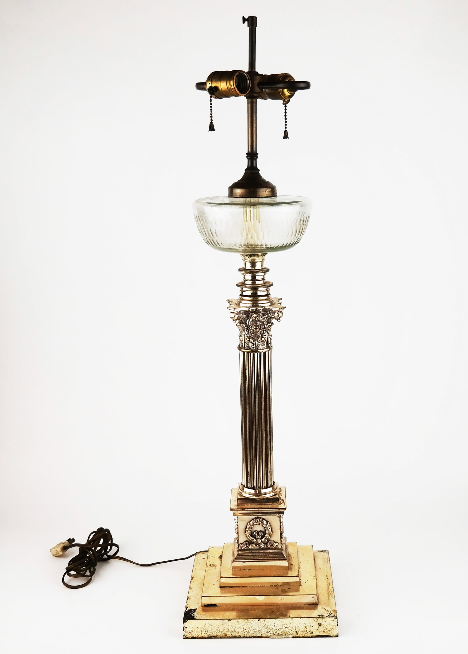 Silver Plate Metal and Glass Oil Lamp: Silver plate, metal and glass oil lamp, designed as a Corinthian column resting on a stepped base, now electrified. [32" H]. Losses to metal and silver tone; tarnishing evident.