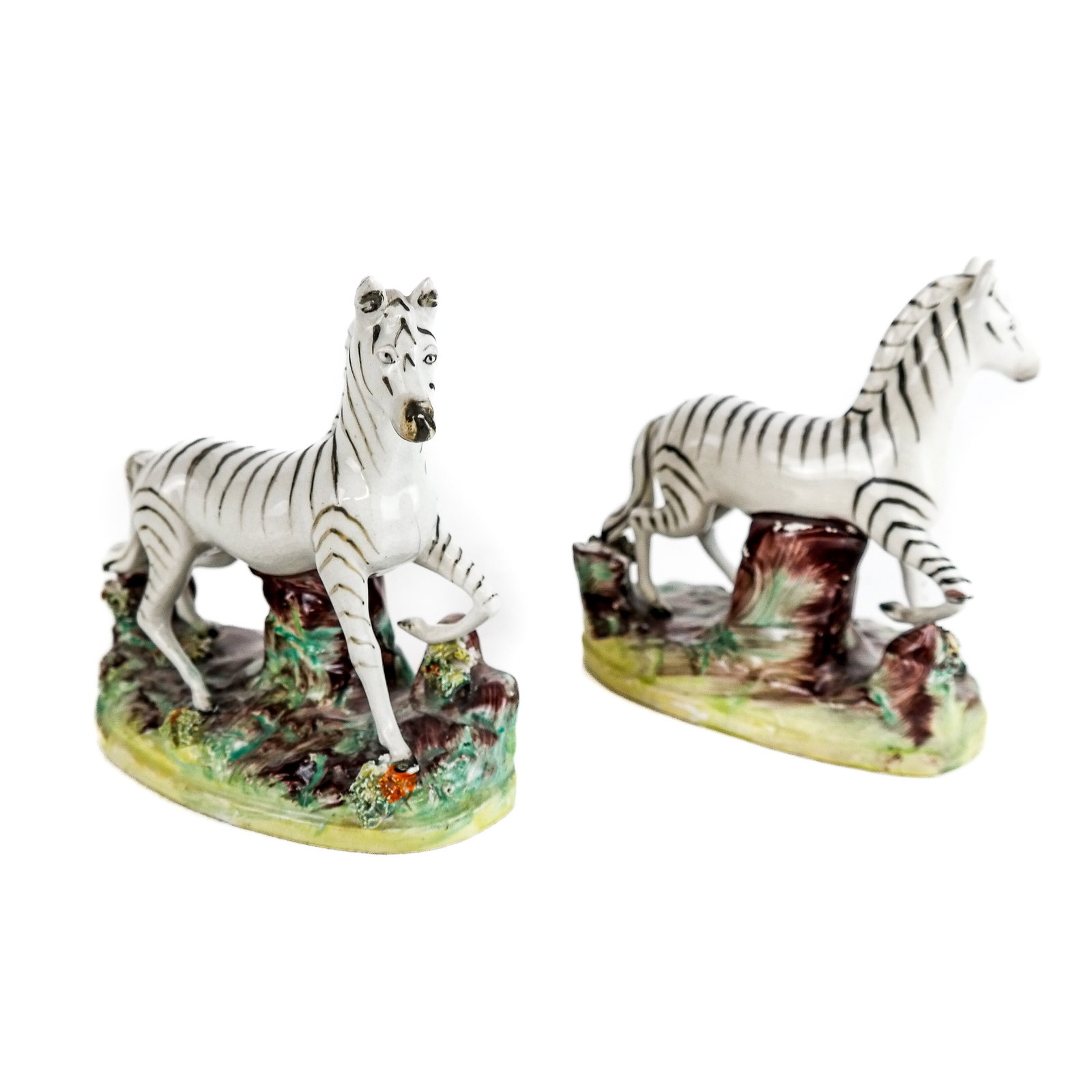 Pair of Staffordshire English Porcelain Sculptures: Pair of Staffordshire English porcelain sculptures modeled as zebras. [5" H x 5" W x 2 7/8" D]. Both overall with crackling to glaze; losses to flowers; firing to bases.