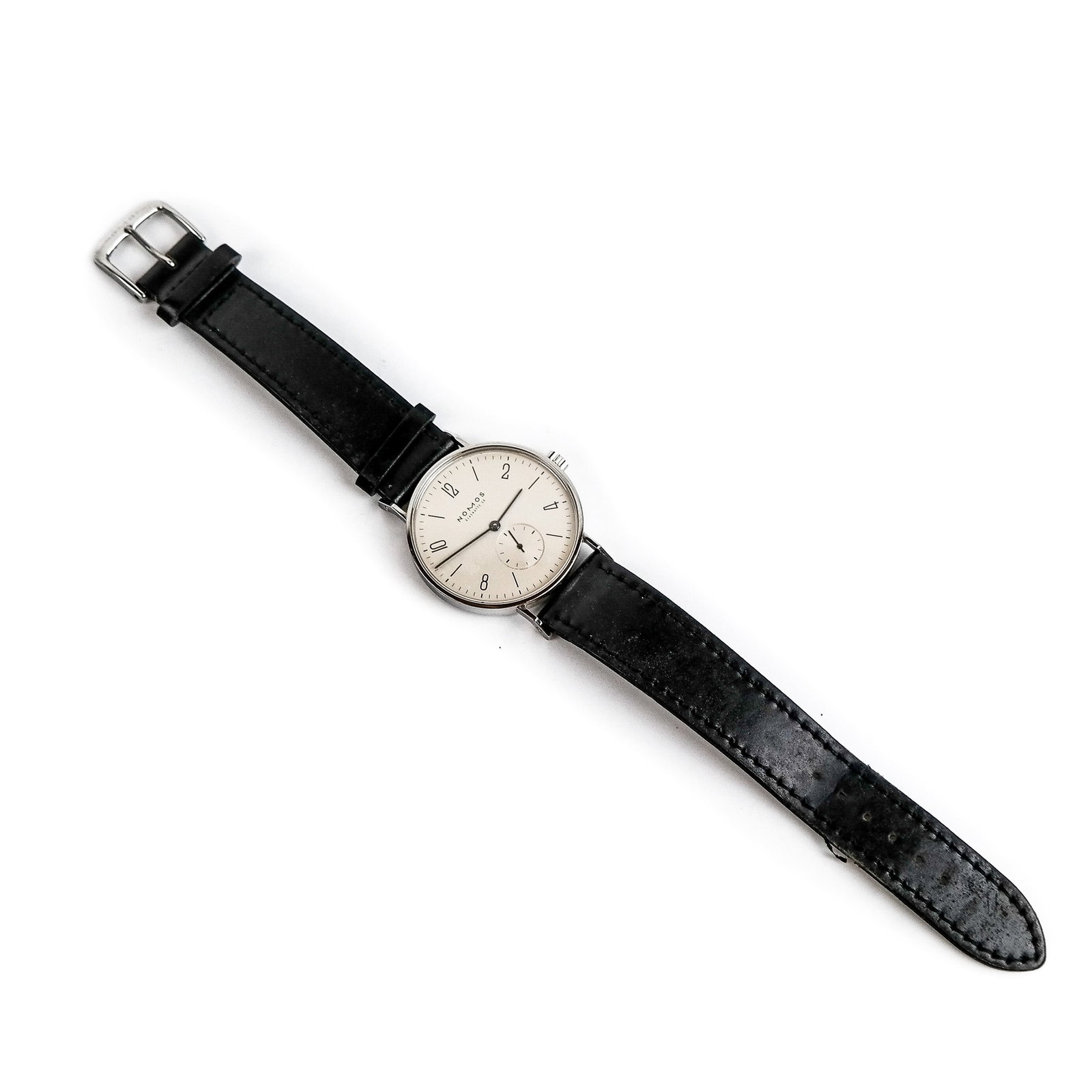 Nomos Tangente Stainless Steel Manual Watch: A Nomos Tangente stainless steel manual wind wristwatch having a silver dial and black leather band, 31mm face diameter, 9093. In good condition with minimal wear.