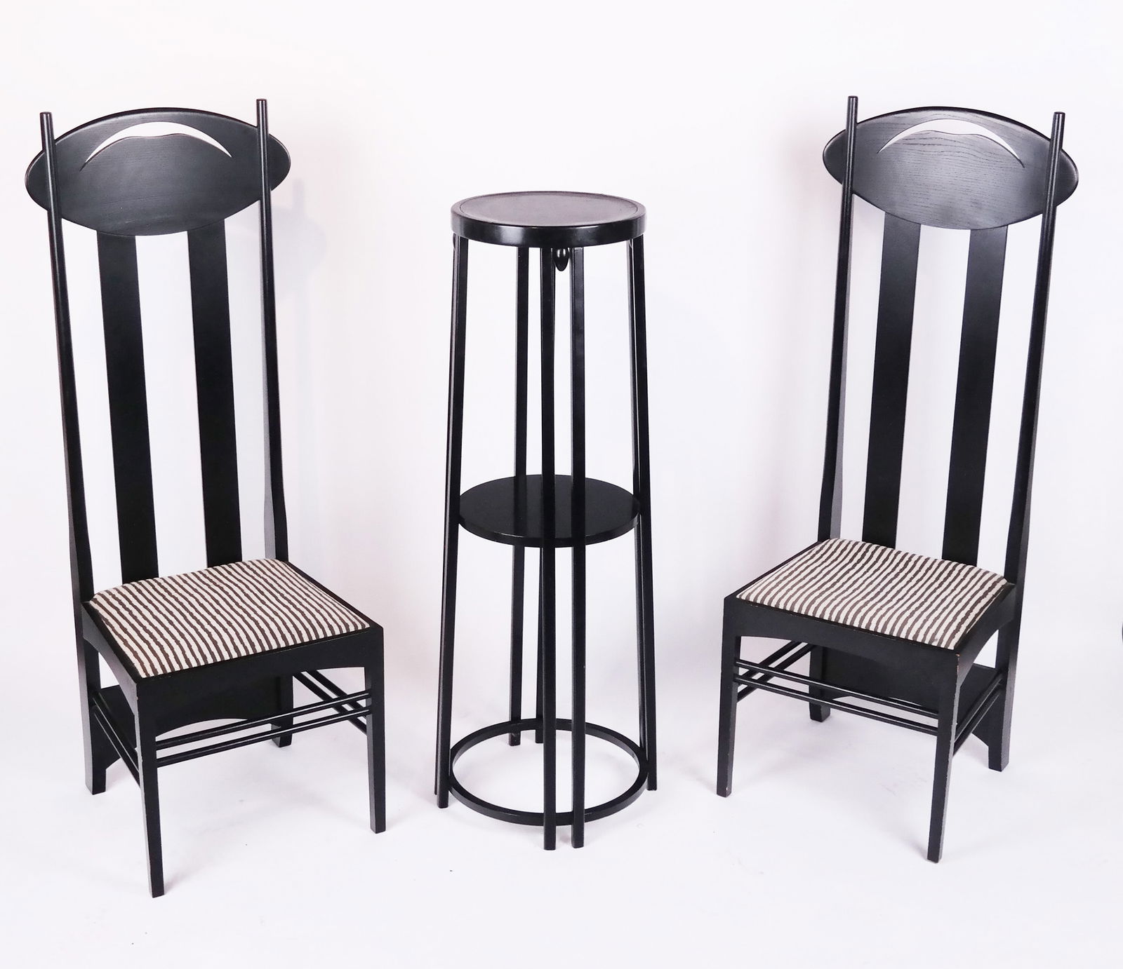 Pair of Mackintosh Side Chairs and Stand: Pair of Mackintosh for Cassina "Argyle" ebonized wood side chairs, stamped, together with a fern stand. [Fern stand: 47" H x 16 1/2" Diam.]. Chips and losses to all pieces; one chair with cracked slat