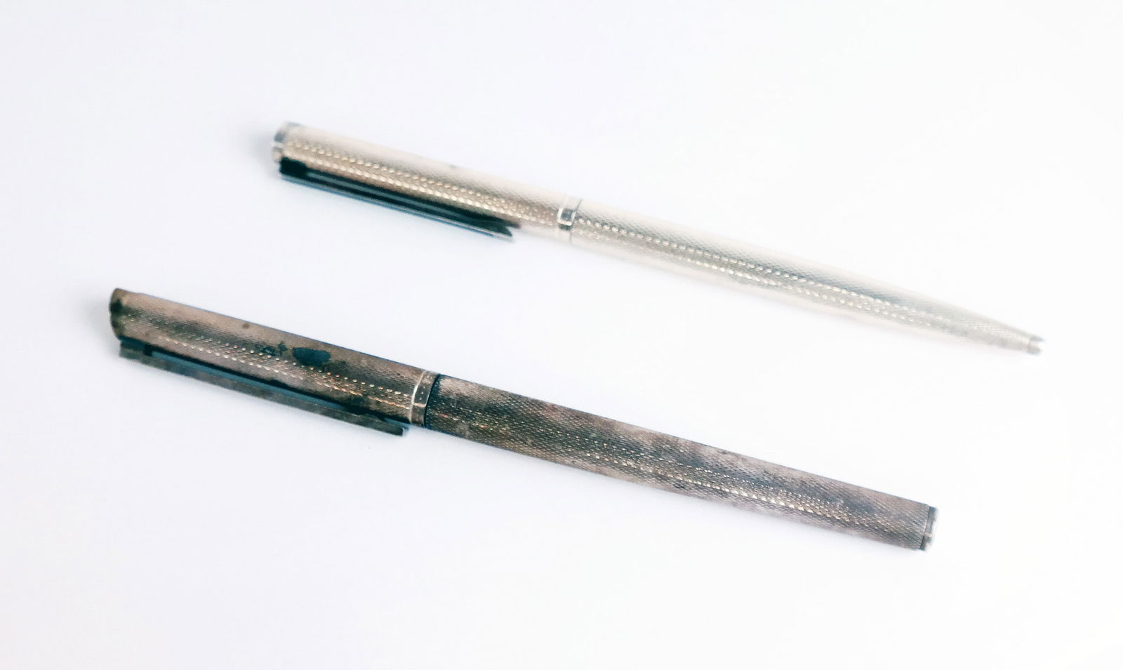 Two Dunhill Germany Pens: Two (2) Dunhill Germany pens, one fountain pen with 14K nib, one twist retractable, both with black enamel clips, likely silver plated.