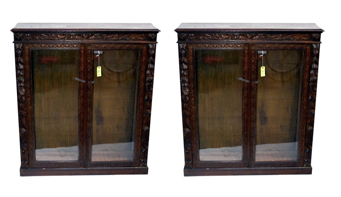 Pair of Oak Bookcases: Pair of Victorian fruit carved two door bookcases, North Wind face appliques. Good condition. 48" L x 12 3/4" D x 53 1/2" H.
