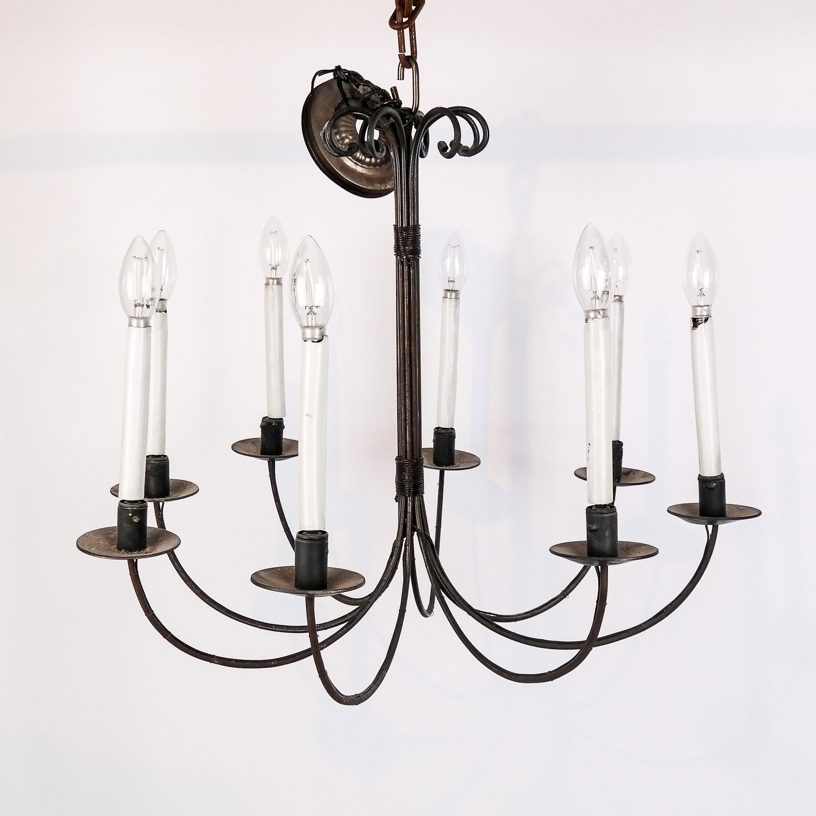 Wrought Iron Eight-Light Chandelier: Wrought iron eight-light chandelier. [21" H x 25 1/2" Diam.]. Condition reports and requests for additional photos cannot be accepted on this lot, please bid accordingly. This is not an indication of 