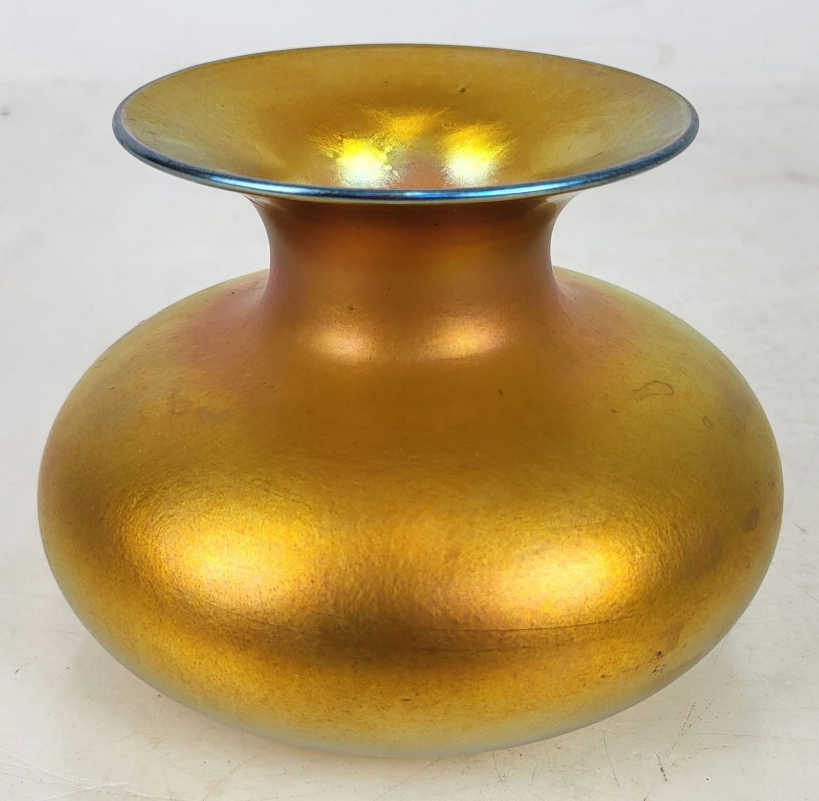Gold Iridescent Glass Squat Vase: Flare-top squat-bodied iridescent gold vase marked (possibly) "#10" on bottom. [4" H x 5 1/2" Diam.]. Condition reports and requests for additional photos cannot be accepted on this lot; please bid ac