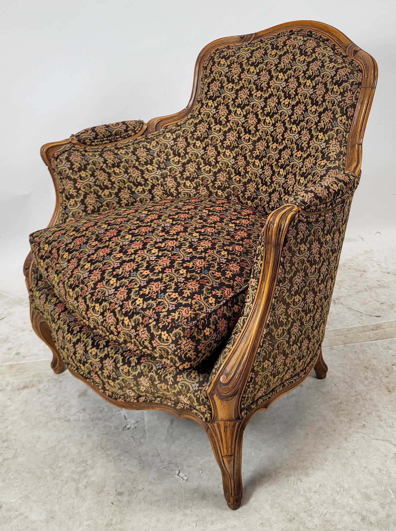19th C. French Provincial Bergere: Louis XVI-style bergere with scrolling tendril and floral upholstery. [33" H x 28 1/2" W x 30 1/4" D]. Light wear; sold "as-is".