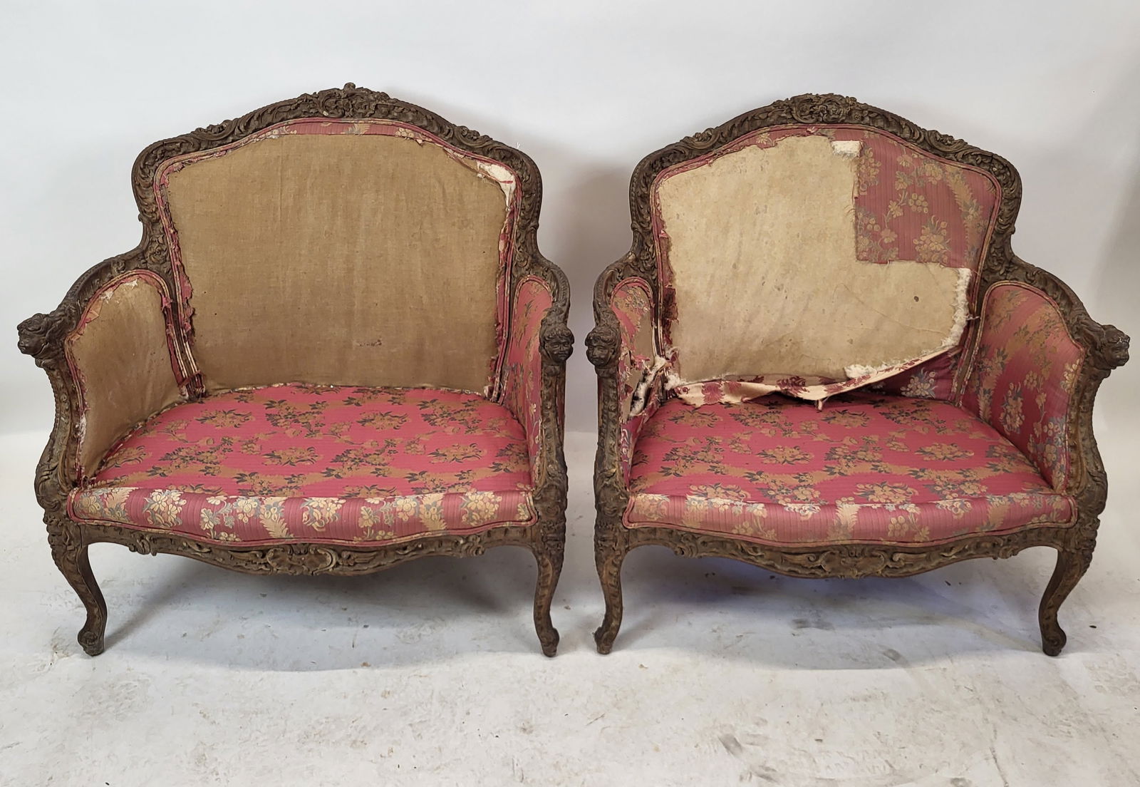 Pair of 19th C. Cherub Relief Settees: Pair of antique floral and cherub carved settees. [35" H x 35 1/2" W x 22" D]. Upholstery "as-is"; no cushions.
