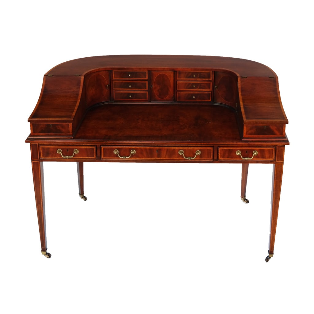 Wellington Hall Carlton House-Style Writing Desk: American, mahogany banded, English style Carlton House desk, with brass hardware, on brass castered feet. [39 1/4" H x 52 3/4" W x 28" D].