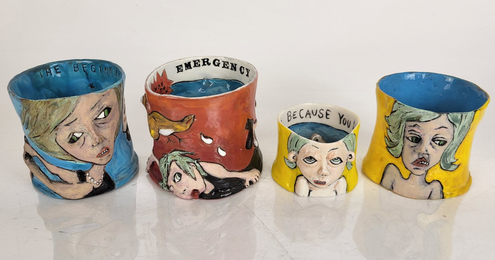 Gina FOWLER: Set of Four Portrait Mugs: Four portrait mugs by Gina Fowler (American, 20th C.). Inscribed/titled to bases: "Splat"; "Nerd Girl"; "Wear a Dress"; and "The Beginning". Provenance: From the Collection of Brendelle & Fred Walden.