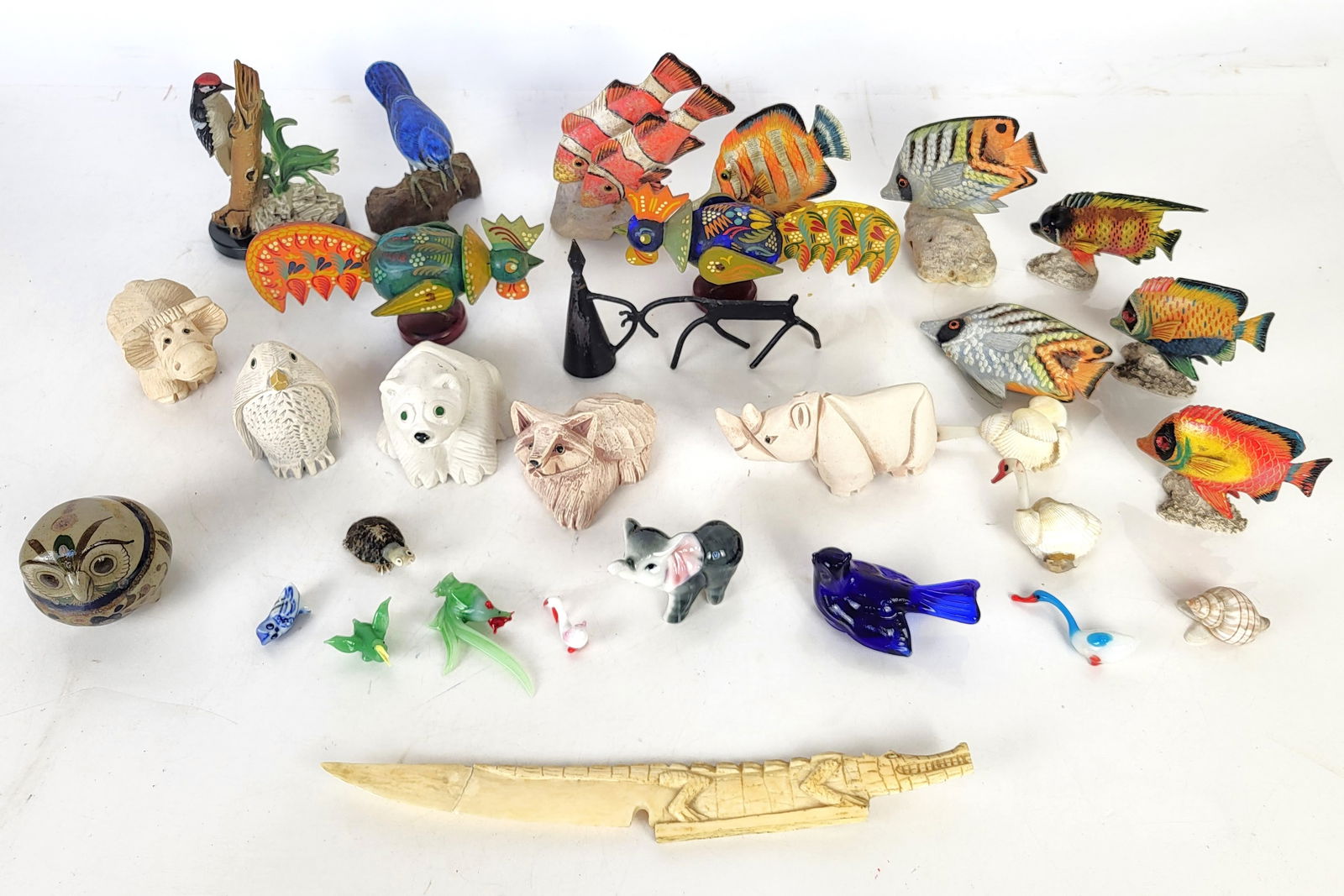 Group of Small Animal Figurines: Mixed material group of animal sculptures, including 7 hand-painted wood fish, 6 handmade ceramic animals, two porcelain and 5 glass sculptures, four shell sculptures, two mixed media sculptures, a me