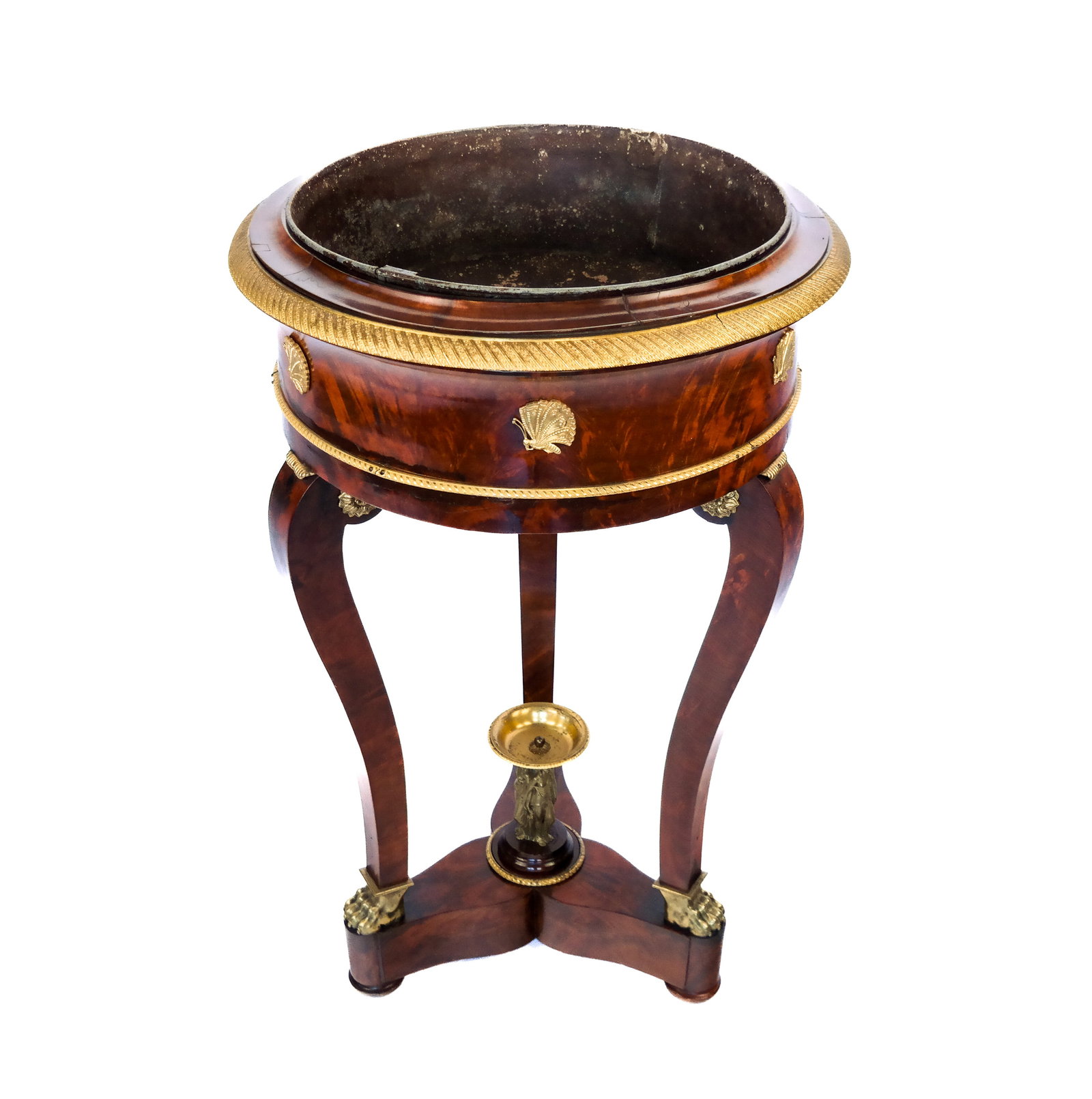 French Empire Bronze Mounted Wine Cooler/Planter: A French Empire flame mahogany gilt bronze mounted circular wine cooler/planter having a lead liner, Classical bronze mounts, three sabre legs on paw feet, and a silvered bronze finial of the Three Gr