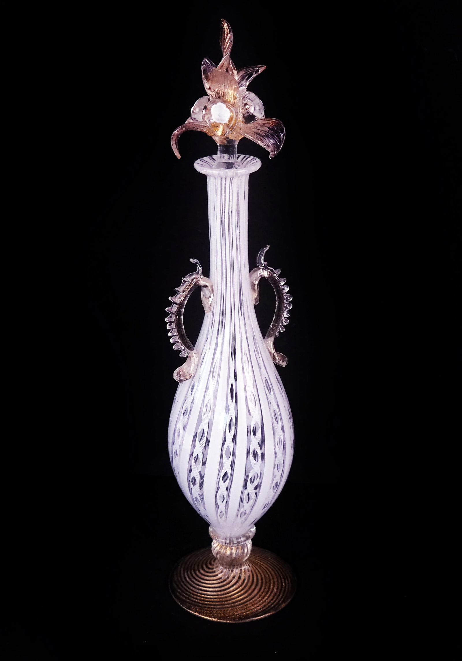 Tall Venetian Crystal Scent Bottle: A tall Venetian scent bottle in the manner of Venini, on a gilt swirl base with ovoid form white decorated interior and scaled swags, having a gilt and white floral stopper. [15" H]. Property of an im