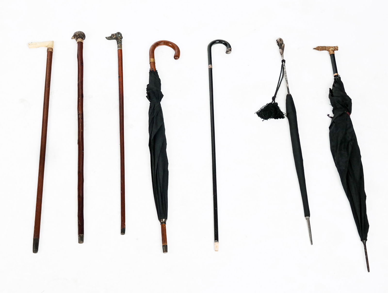 Canes, Umbrellas and Parasols, 7: Three umbrellas, including one with an eagle head handle, one with a floral handle, another plain, together with a group of four canes/walking sticks, including one with a dog handle, a snake handle,