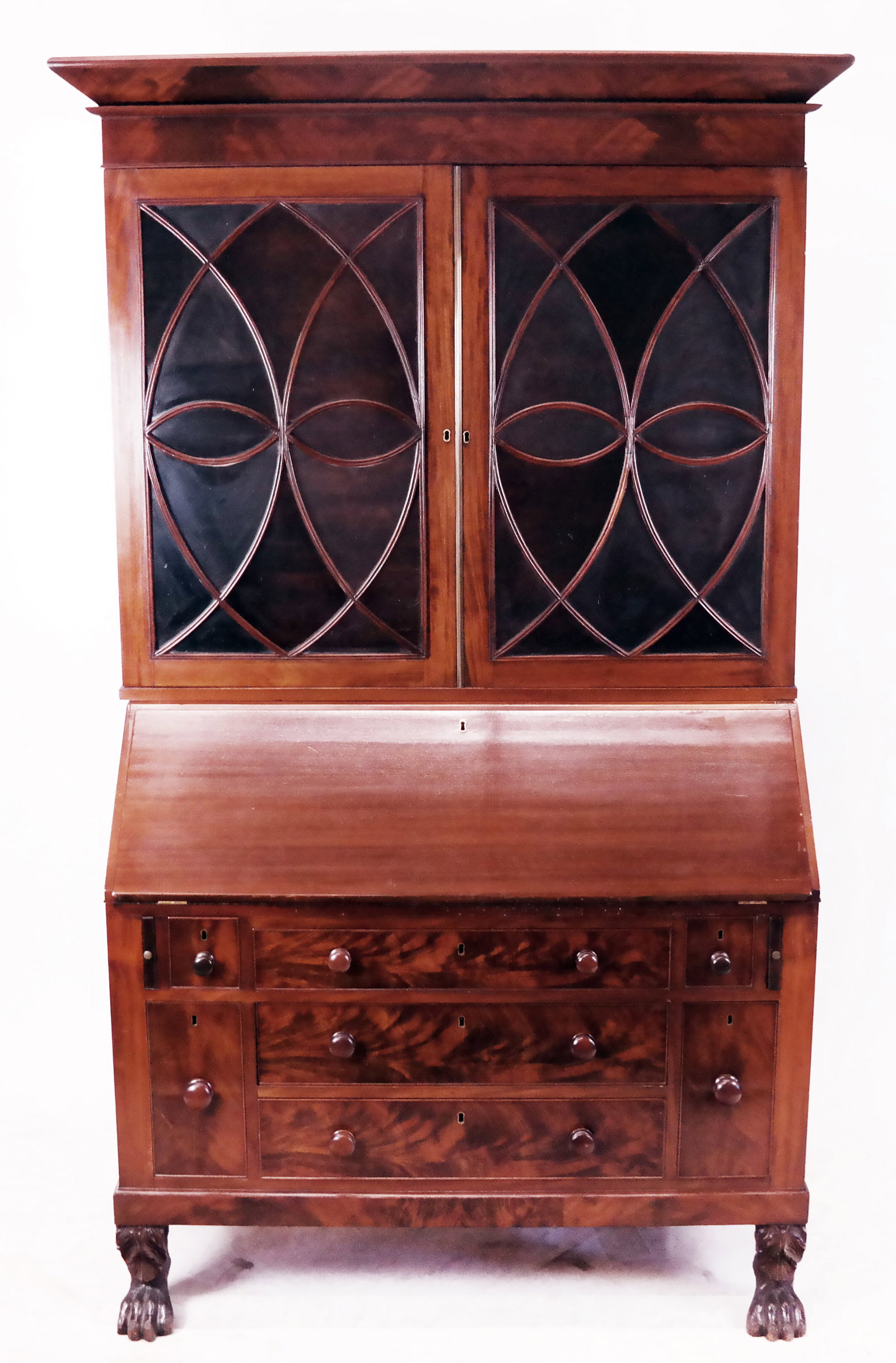 Centennial Mahogany Secretary: Centennial mahogany secretary, 19th century, in two parts with mullion glass doors, a fitted interior, two wine drawers, and paneled sides; original divider present; raised on hairy paw feet. [81.25" 