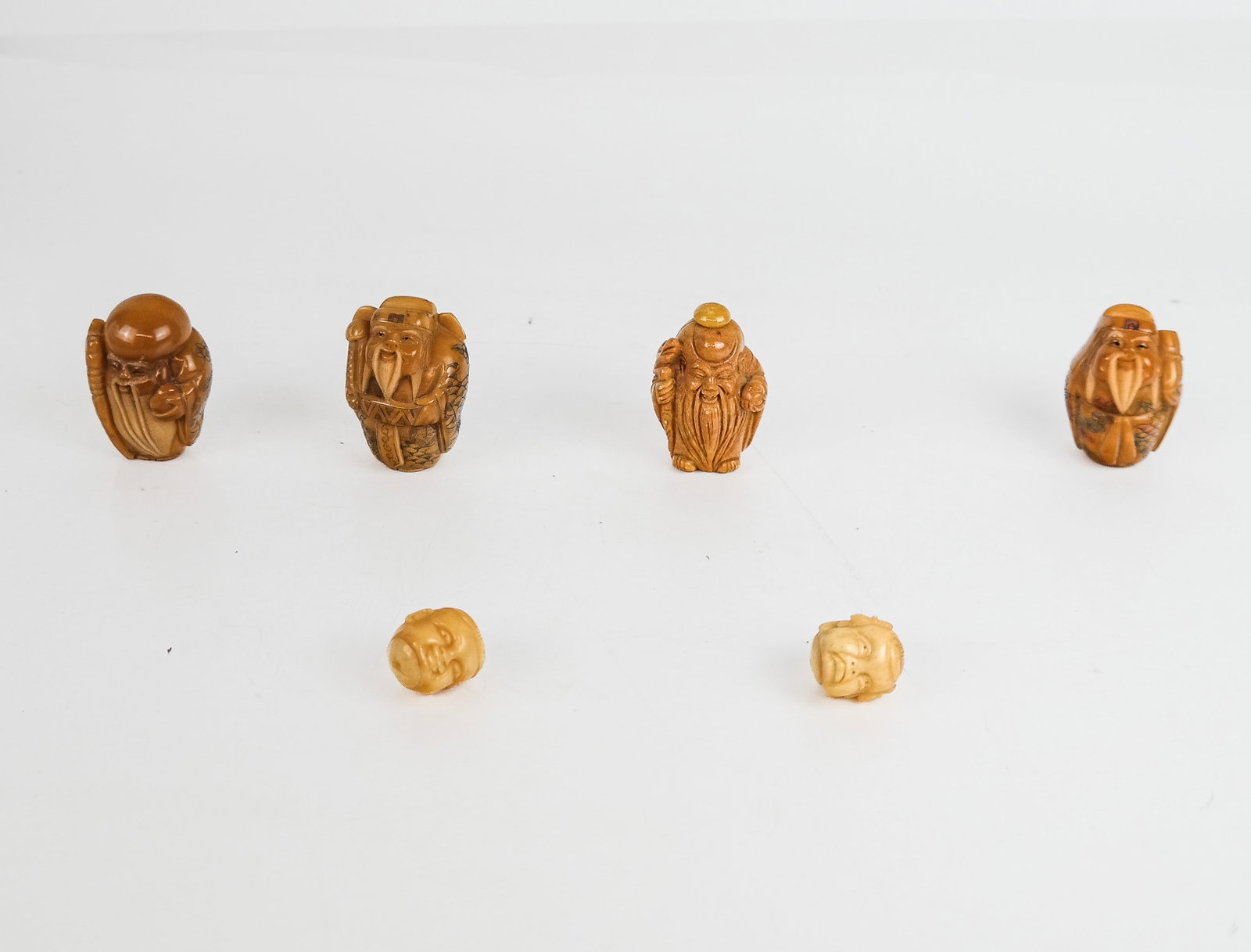 Group of Carved Resin & Bone Figures and Beads (6): Group of carved resin and bone figures in the Asian taste comprising 2 carved head beads, and four old man figures with canes and long beards.