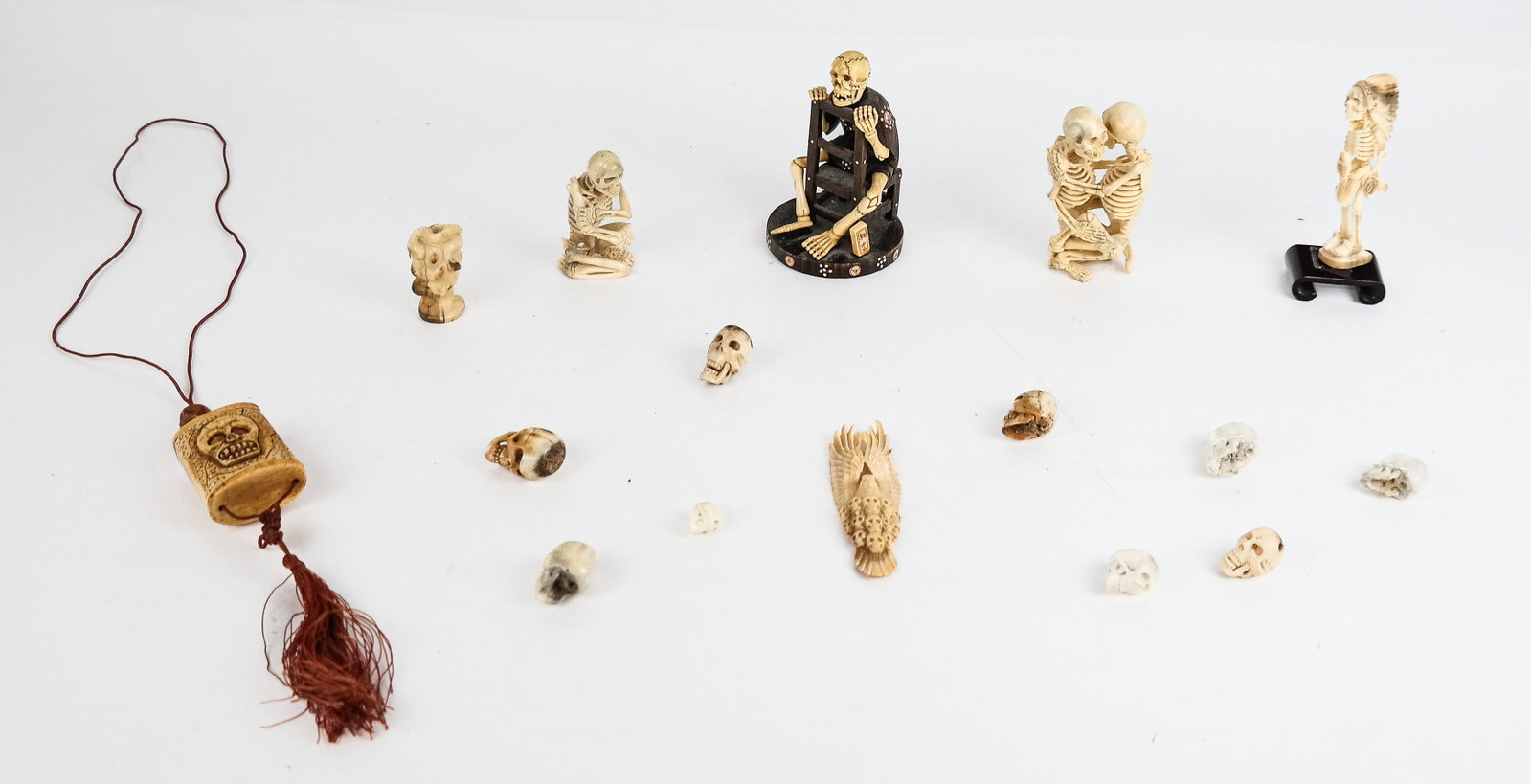 Group of Carved Skull and Skeleton Figures (15): Group of carved bone, resin and wood skull and skeleton figures comprising 4 figures, 1 necklace, 1 winged fragment, 9 skulls, and Medusa