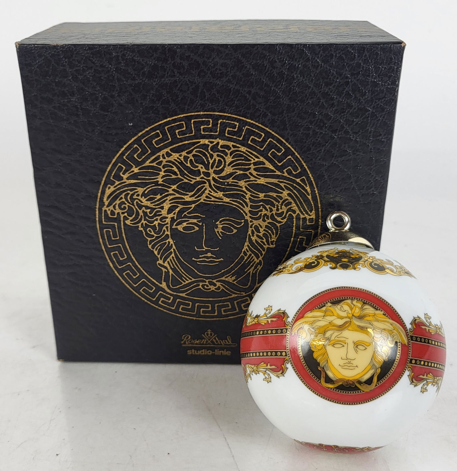 Versace Rosenthal Ornament: Versace Rosenthal porcelain Medusa ornament with original box. [3" Diam.]. In good condition. Condition reports and requests for additional photos cannot be accepted on this lot; please bid accordingl