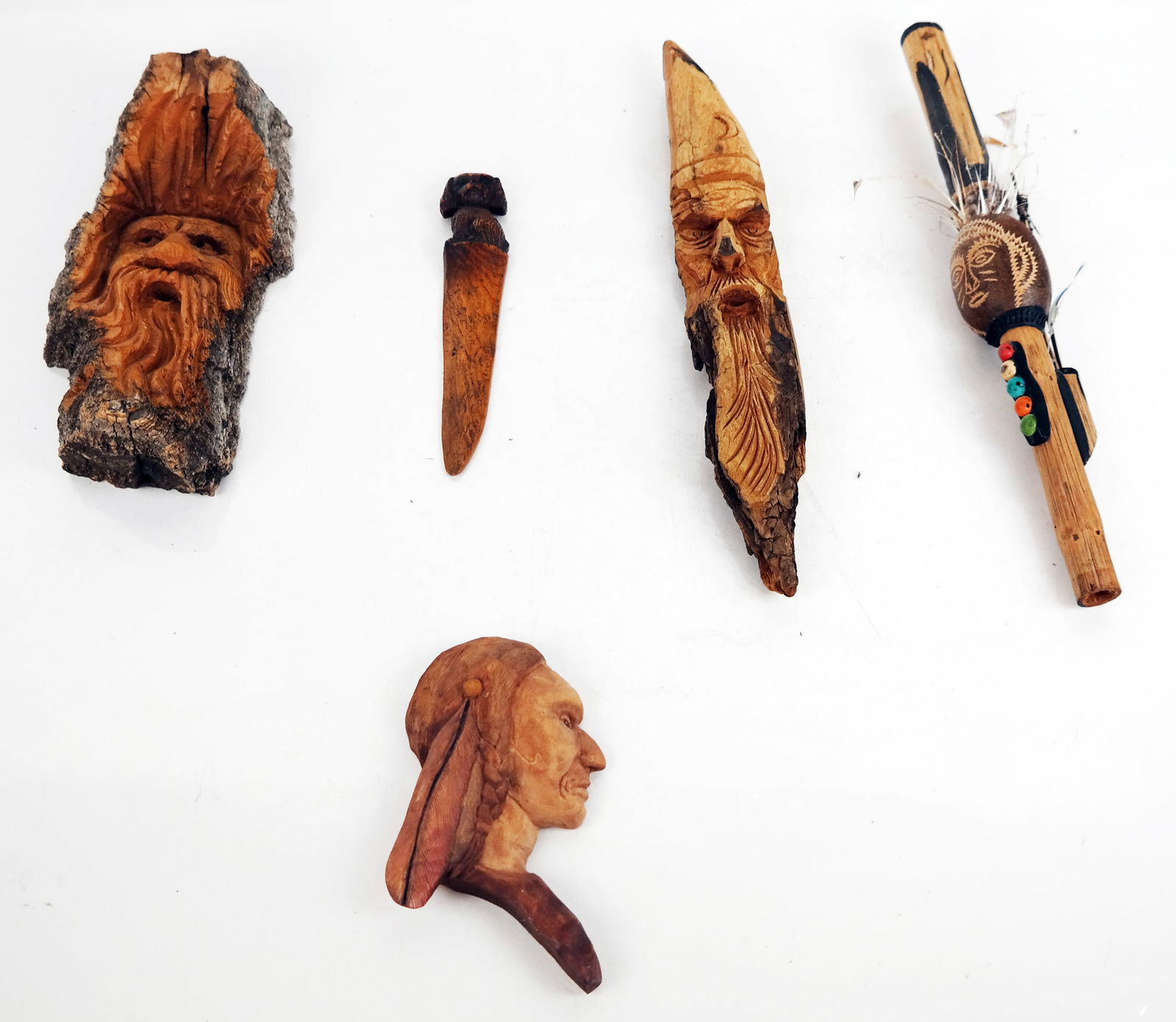 Five Hand-Carved Wood Objects: Group of hand-carved wood objects, including two faces, a profile, a letter opener and a dart gun. [Largest: 9 1/4" H x 4" W x 2" D]. In overall good condition. Condition reports and requests for addi