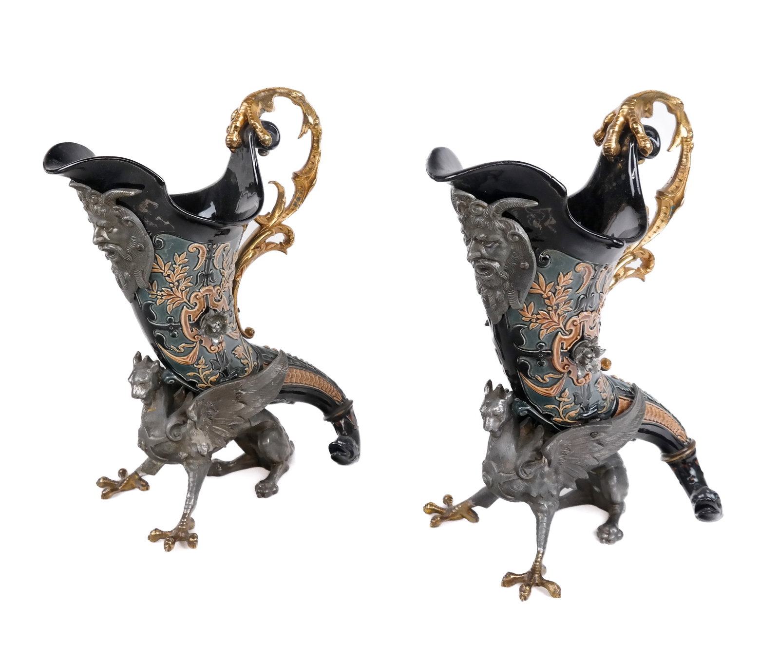 Pair of Pewter, Majolica and Gilt Metal Ewers: Pair of pewter satyr, griffon and cornucopia majolica ewers with scrolling and talon form gilt metal handle [13" H x 6" W x 9.5" L] Overall condition is good. Property from an Old Westbury Long Island