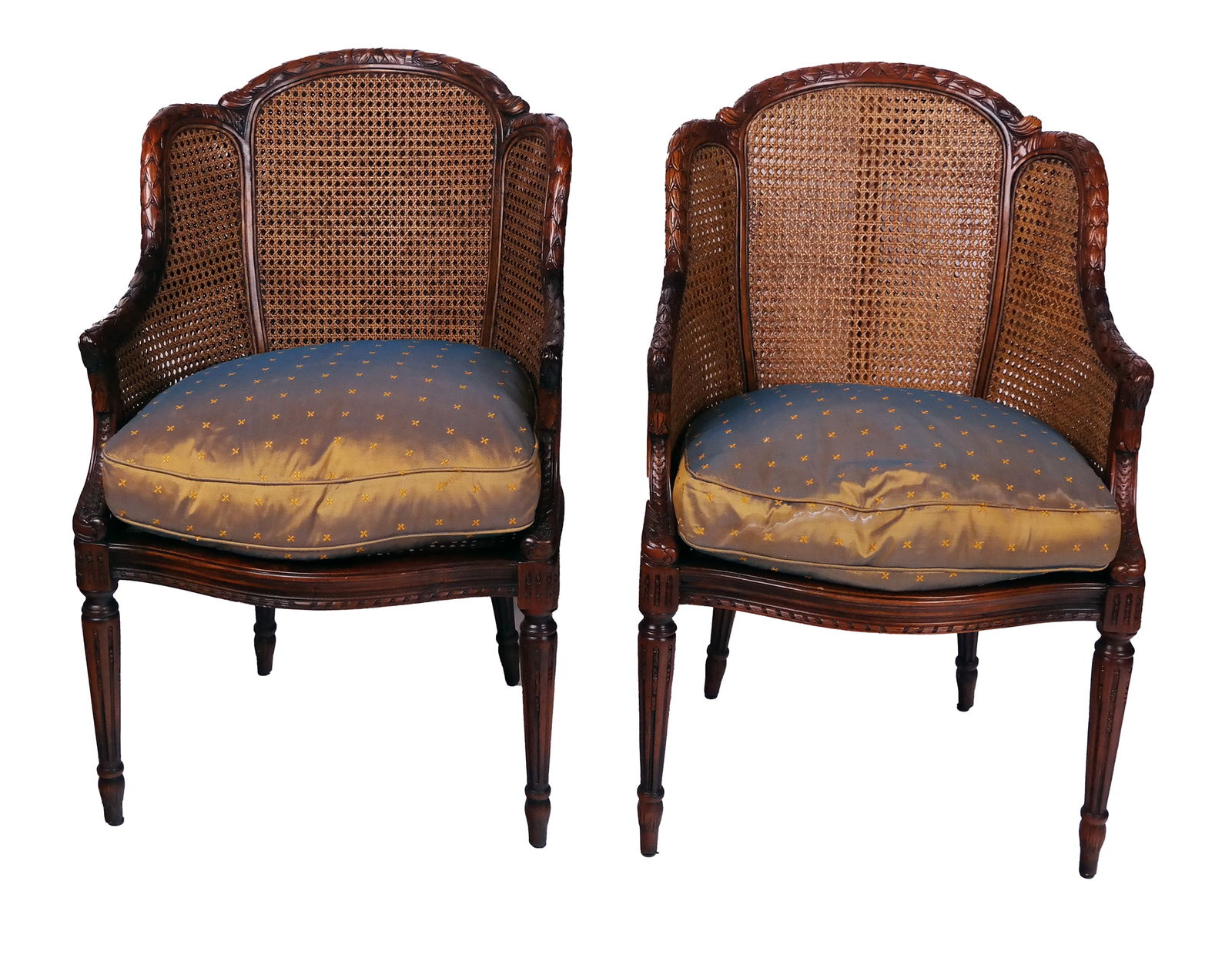 Pair of Louis XVI Mahogany and Caned Bergeres: Pair of Louis XVI carved mahogany and cane bergeres, 20th century, with upholstered seat cushions [39" H x 24" W x 22" D, 17" H to seat; 24" to seat with cushion] Overall condition is good, with remov