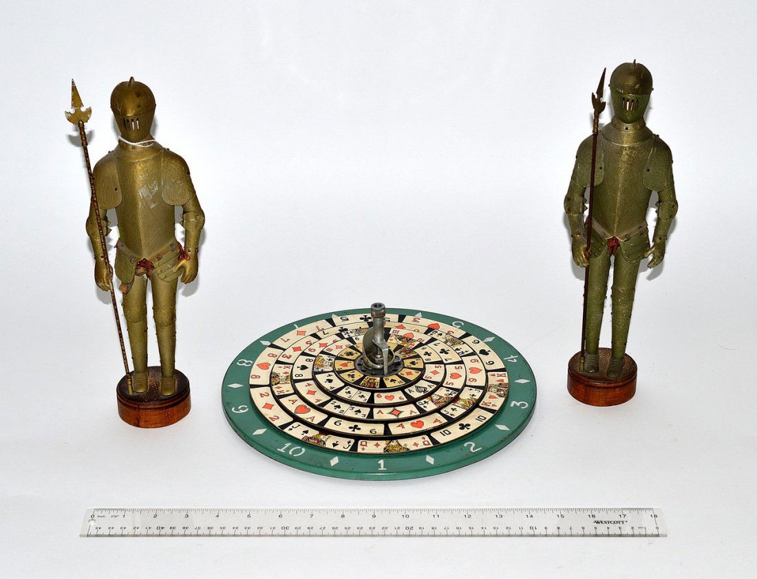 Miniatures Group Lot: Comprises two small knights in armor figurines with sheet metal armor. Accompanied by a miniature roulette wheel. Knights: 13"H. Wheel: 12" Dia. All in vintage condition with a small rip in rear of on
