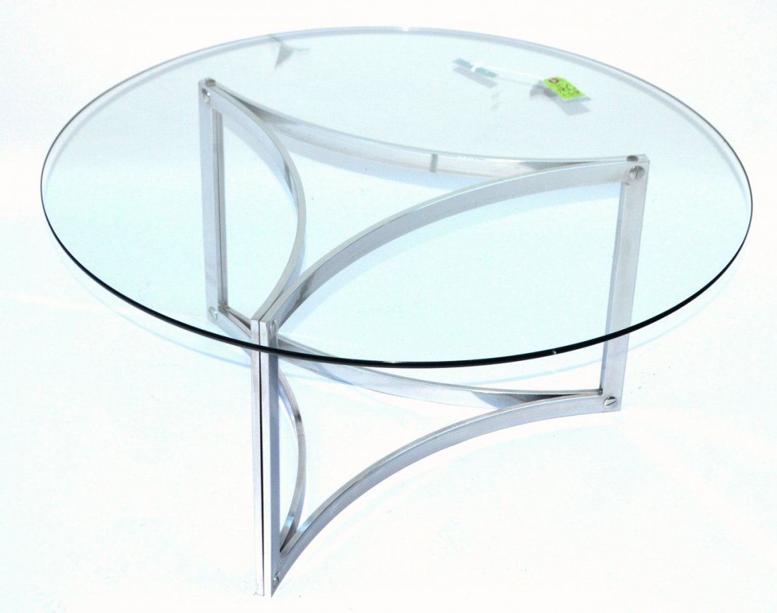 Mid Century Modern Glass and Chrome Cocktail Table: Bears a circular glass top on a chrome bas, composed of triangular concave supports. 36" dia. x 16" H. Light pitting.