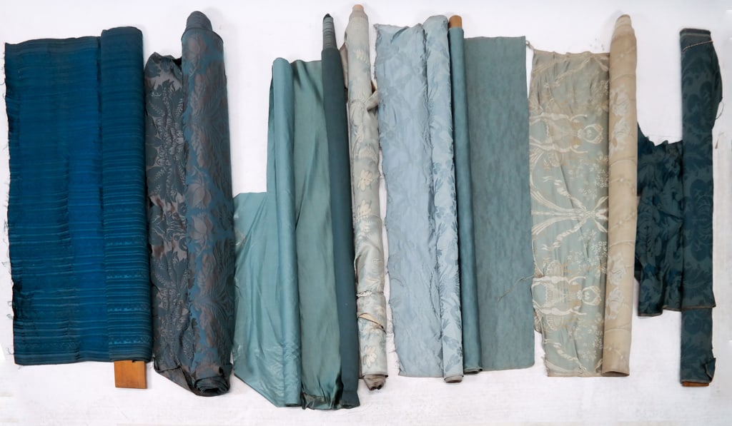 9 Bolts of Blue Furnishing Silks & Damasks: A group of 9 bolts of blue furnishing silks and damasks circa 1920's-1930's, including: five bolts of 18th Century style floral damasks; two plain blue silk satins; one roll of glazed cotton; and one 