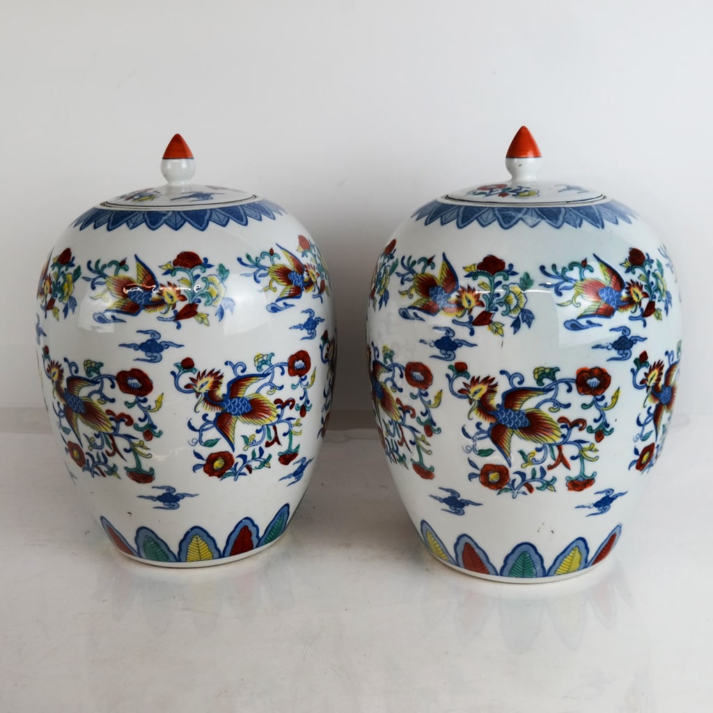 Pair of Japanese Arita Porcelain Ginger Jars: Pair of Japanese Arita porcelain ginger jars, circa 1900, late Meiji Period, with kakiemon polychrome decoration of basan and tengu birds among the clouds, bearing blue triangle mark to base. [13" H x