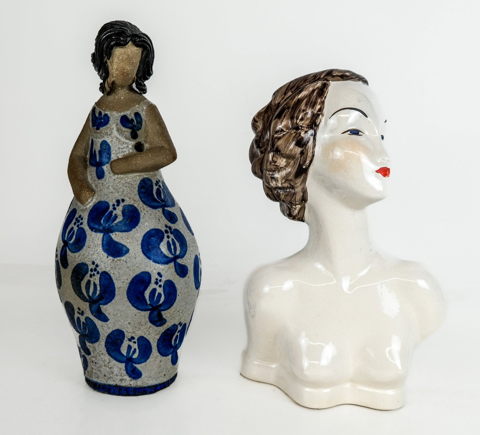 Two Sculptures of Women: A 1950s nude porcelain bust and a ceramic sculpture of a woman in a blue and white dress. [Larger: 12.5" H]. Condition reports and requests for additional photos cannot be accepted on this lot; please