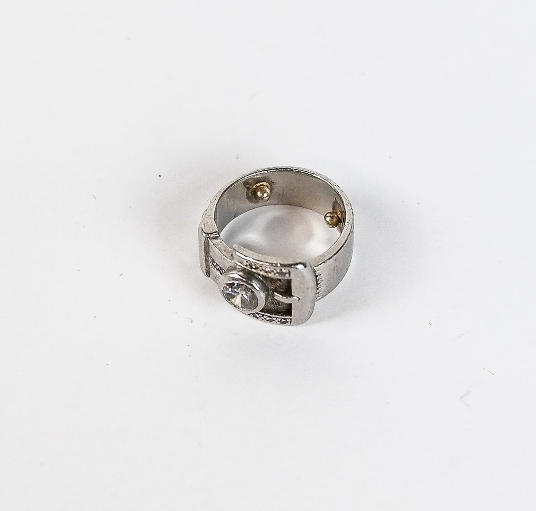 Diamond and Platinum Ring: Diamond and platinum strap ring, collet-set center round brilliant-cut diamond approximately .50 carat, accented with small single-cut diamonds, 7.1 dwt. Marked platinum. Overall condition is good wit