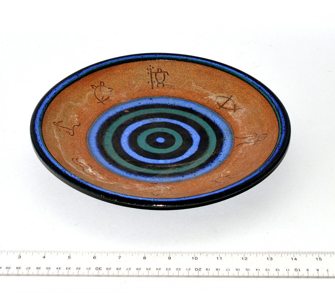 Studio Ceramic Charger: Glazed earthenware charger with band of incised symbols around a bull's-eye design at center. Signed "Ali Maui '99" on bottom. In good condition.