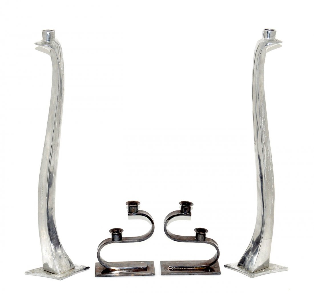 Two Pairs of Sculptural Candlestick Holders: Comprises of a pair of silver plate two-light candlestick holders on "S"-form supports. Each 6"W x 3"D x 7"H. A pair of tall cast and polished aluminum candlesticks with label "Escapade/Paris" on bott