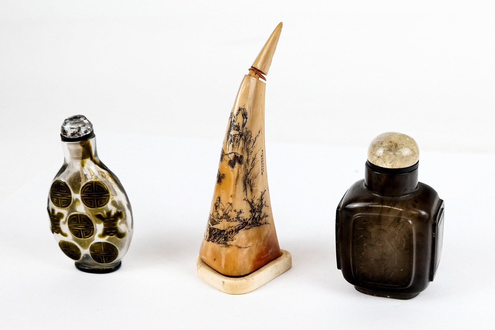 Chinese Hornbill, Quartz, & Other Snuff Bottles, 3: Three Chinese snuff bottles including a painted hornbill snuff bottle on a carved bone stand, a glazed glass snuff bottle , and a black quartz snuff bottle with Three Legged Toad inscription. [Tallest