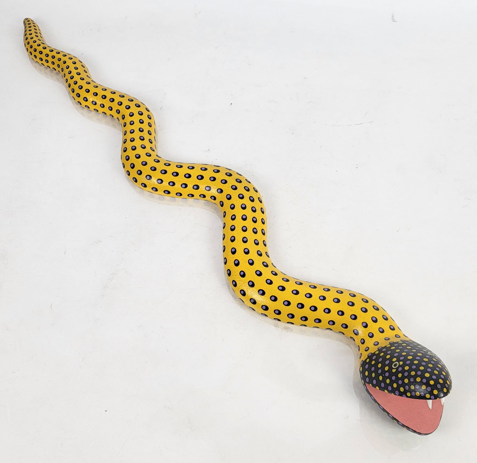 Dirk KORTZ: Folk Art - “Wood Serpent," 1987: Dirk Kortz (American, active 1980s). Wood Serpent, 1987 hand-carved wood snake sculpture with painted long yellow body having contrasting dot motif decoration, artist signed and dated underside "Dirk 
