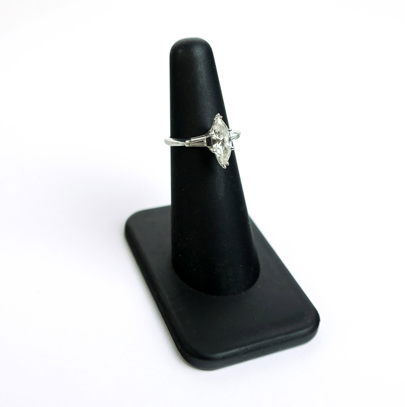 Platinum And Diamond Ring: Platinum ring with marquise-shaped diamond, approx. 11.6mm x 4.7mm with two flanking small diamonds. 4.1 grams total weight., ring size 4.75 Break in ring at bottom of loop.
