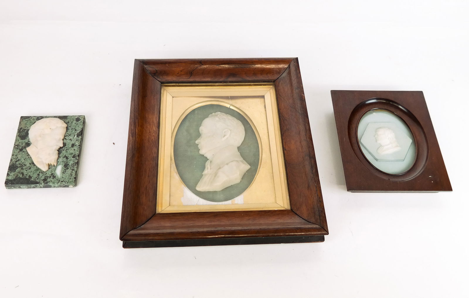 Three Relief Sculptures: Three relief sculptures, including two in frames and one on a composite tile. [Larger frame: 13.5" H x 11.5" W x 1.75" D; Largest relief: 5.75"]. Condition reports and requests for additional photos c