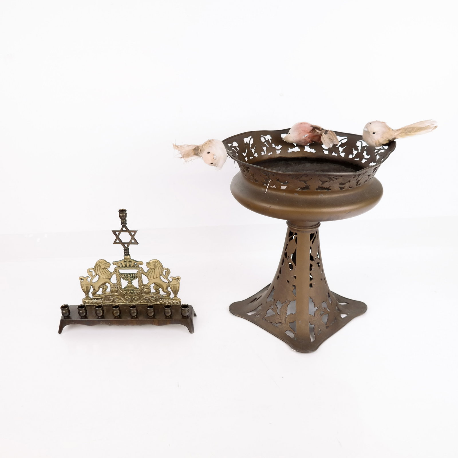Mixed Media Menorah And Compote (2): Menorah with lion adornments and an open metal compote. [Menorah: 8" H; Compote: 12" H x 10" diameter]. Condition reports and requests for additional photos cannot be accepted on this lot; please bid 