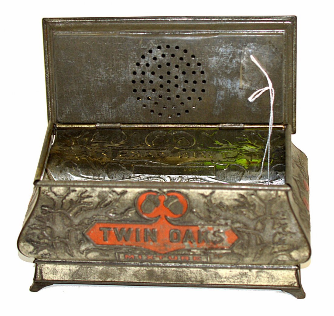 Two Twin Oaks Miniature Tobacco Tins: Comprises an uncommon humidor-type box with hollow hinged lid and splayed feet. 8 1/2" W x 4 3/8" D x 4 1/2" H. Accompanied by a pocket tin and hinged flap-form lid. 3 1/2" W x 1 1/4" D x 4" H. Both a