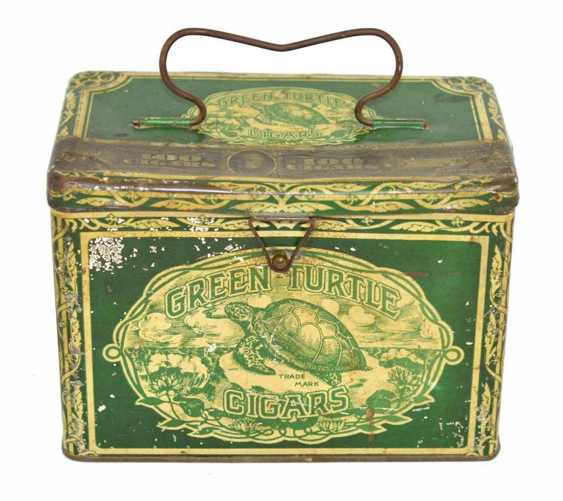 Green Turtle Cigars Lunch Pail-Type Tin: Bears a front latch, hinged lid, and bale handle top. 7 1/2" W x 4 1/2" D x 5 1/4" H. Scratches and scuffs with some dents and loss to printed surface. Otherwise complete.
