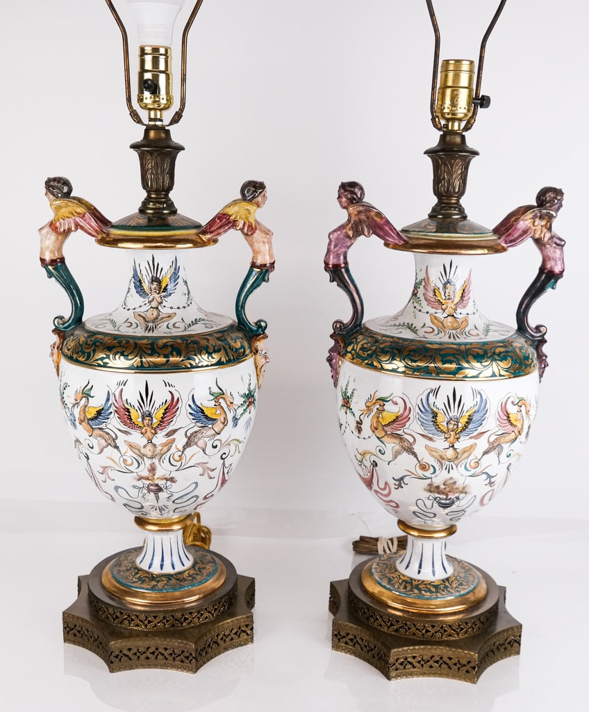 Pair Capodimonte Neoclassical Urn Form Lamps: Pair Capodimonte neoclassical two-handled urn form lamps, Italian 20th century, with harpy form handles, gilt and polychrome decorated with foliate and mythological motifs on a pierced brass base [To