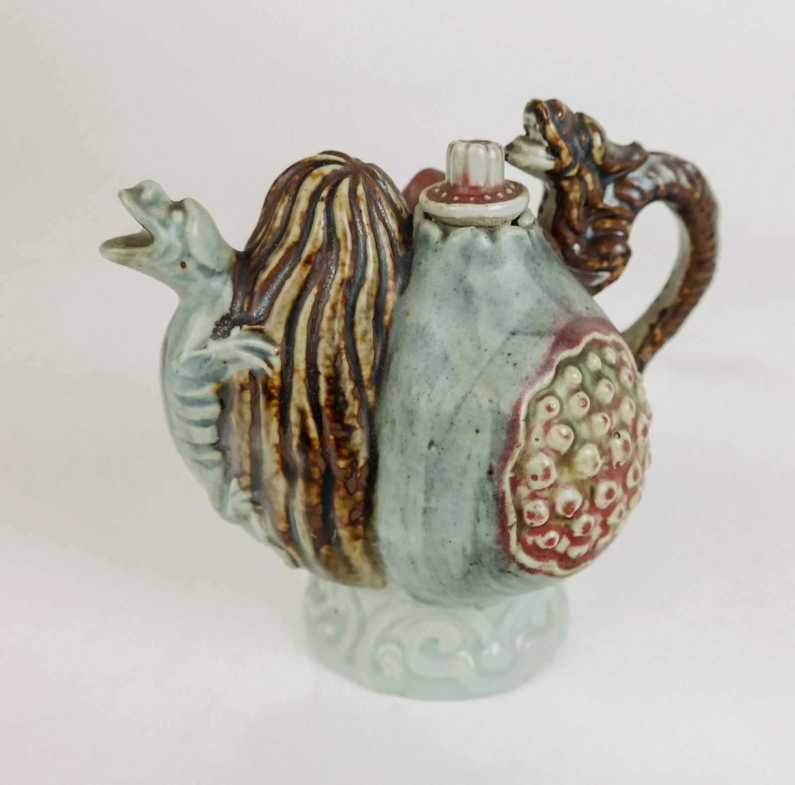 Chinese Qing Dynasty Pomegranate Decorated Ewer: Chinese Qing Dynasty porcelain wine ewer, 19/20th century, with a pomegranate decoration and dragon form handle and spout. [5" H x 4" W x 6" D]. Overall condition is good.
