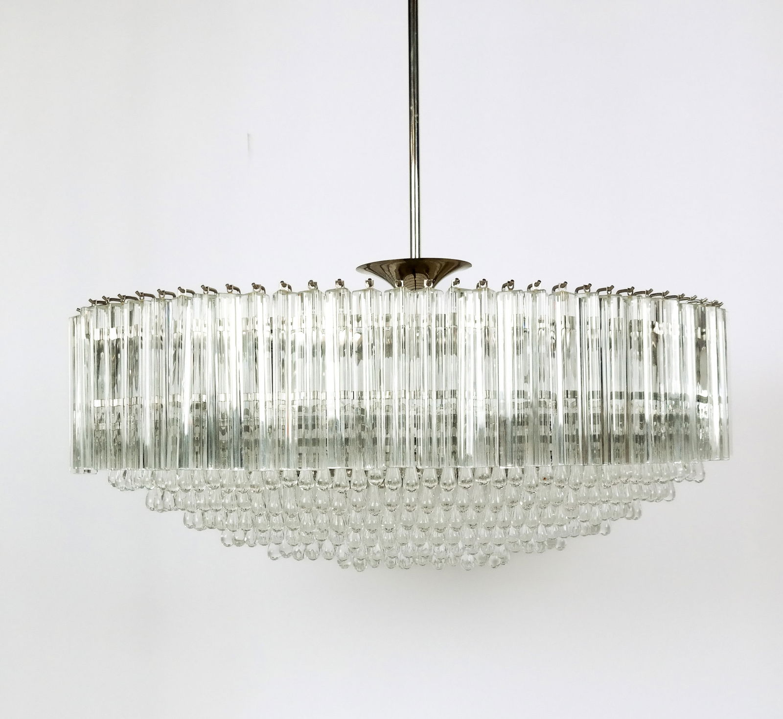 Murano Crystal Chandelier Attributed to Venini: Murano crystal prism and drop chandelier, circa Mid-Century, attributed to Venini in an ovoid form with six rows of drops, bordered by a row of prisms, and set on a chromed metal gantry. [Excluding ro