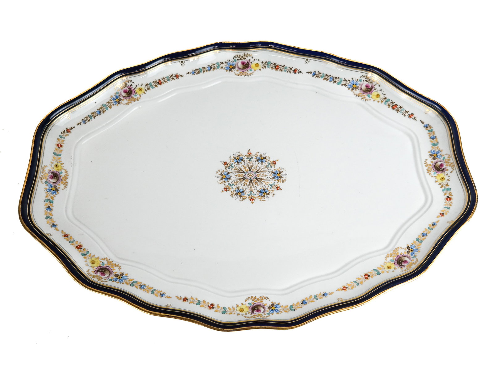 After Meissen Porcelain Platter: After Meissen cartouche shaped platter, probably 20th century, the white ground with cobalt blue border accented with conforming swags of flowers and centering a central medallion, mark to base [1" H 