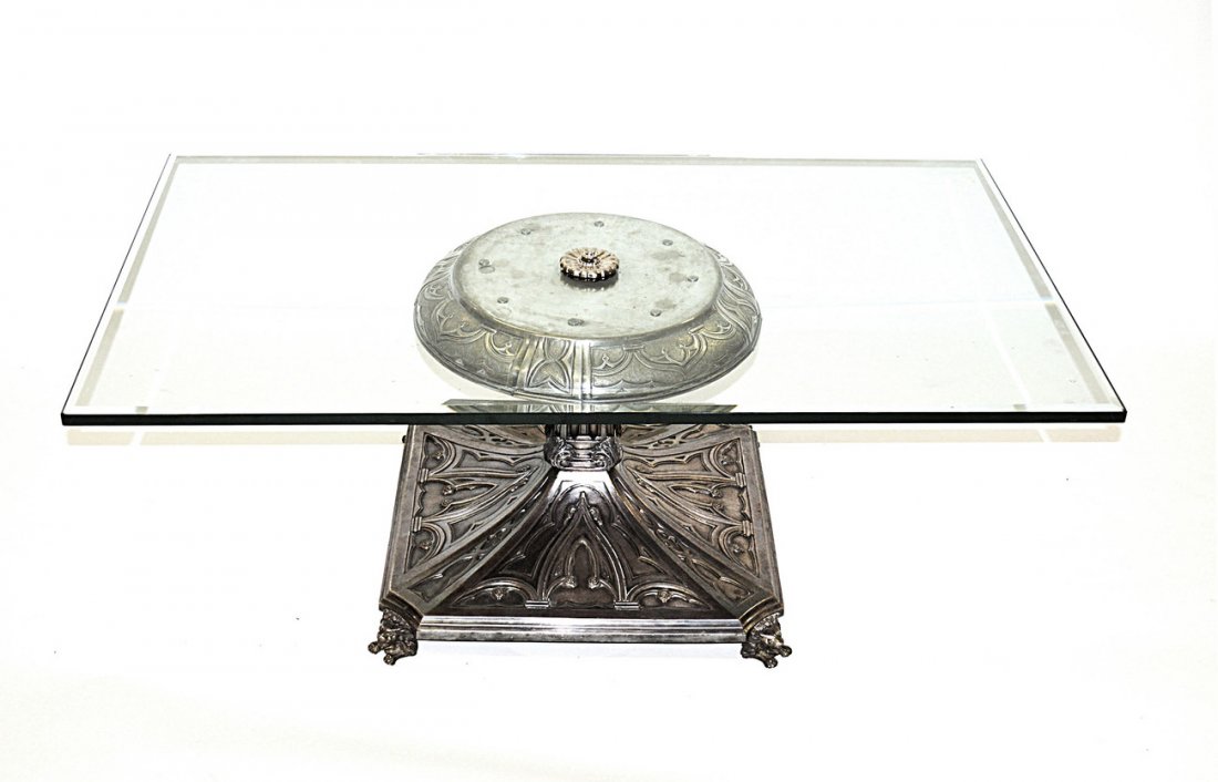 Silvered Bronze Glass Top Cocktail Table: Features silvered bronze gothic style pedestal base with crouched lion-form feet. 48" W x 28" D x 17 1/2" H. In good condition.