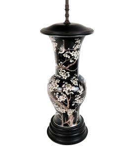 Chinese Famille Noire Vase Mounted as a Lamp: Chinese famille noire vase, Qing Dynasty, mounted as a lamp with cherry blossom and bird design over a black ground, mounted as a lamp with an ebonized wood cap and stand. [To Lip: 19.5" H x 8.5" Diam