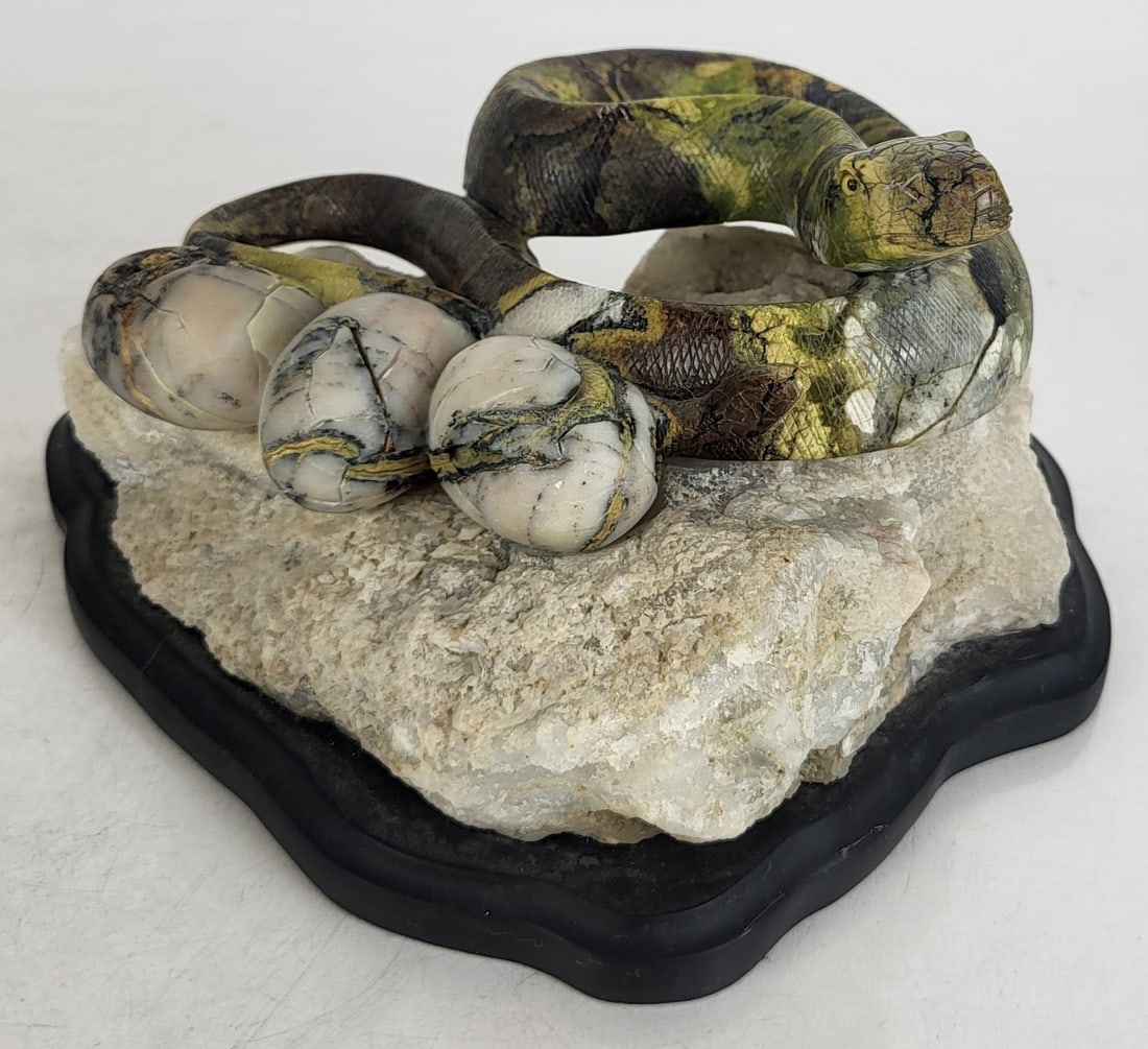 Carved Serpentine Snake Sculpture: Naturalistically carved serpentine snake sculpture, Chinese, possibly by W.K. Ngai, late 20th century, in chartreuse, browns and grays, resting on a quartz and black onyx base, marked " AE 1090 2000 B