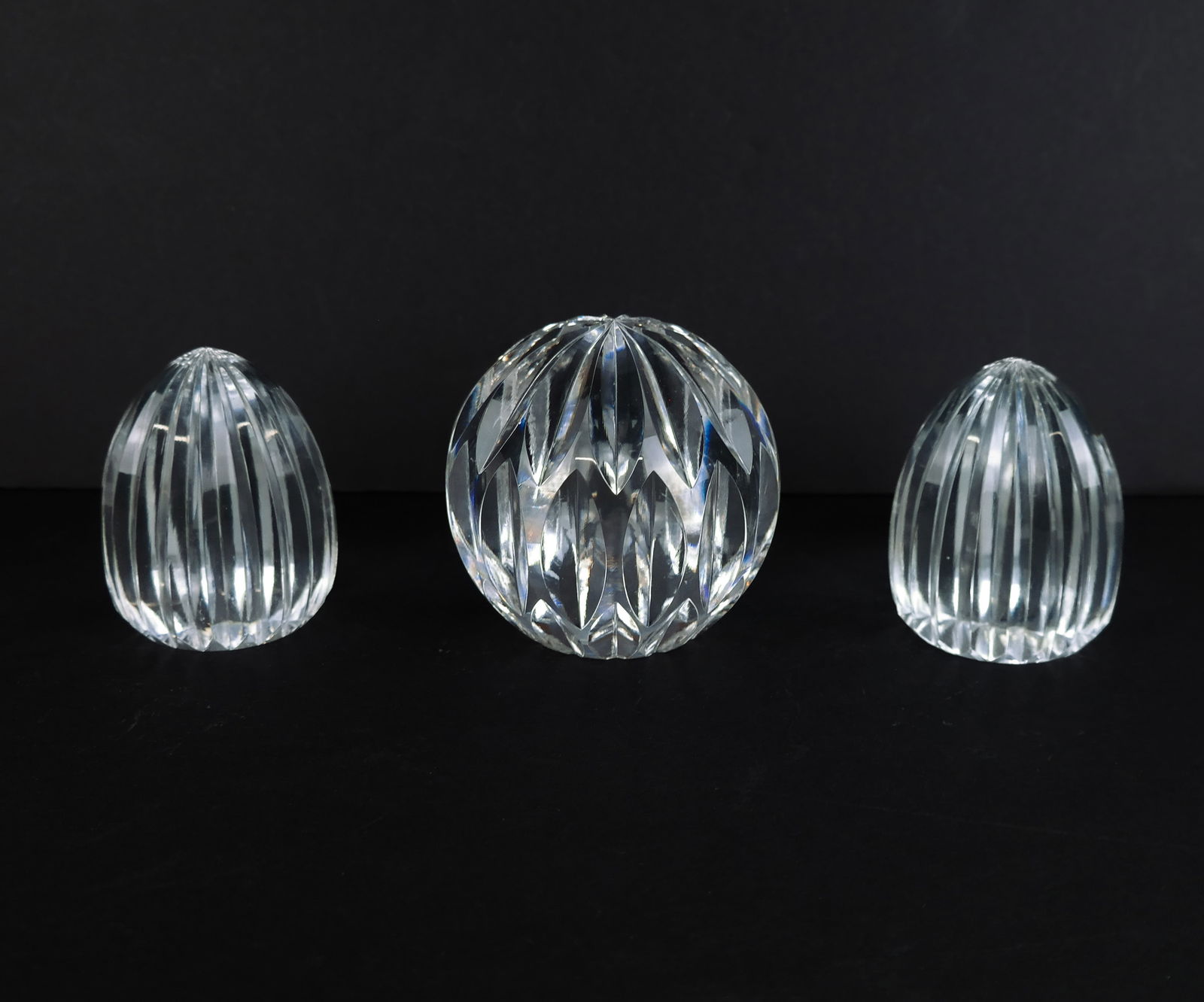 Three Crystal and Glass 'Juicer' Paperweights: Three crystal and glass 'juicer' form paperweights, one signed illegibly to base [Largest: 4" H x 4" Diameter]. Overall condition is good. From the esteemed collection of Neil Zukerman former owner CF